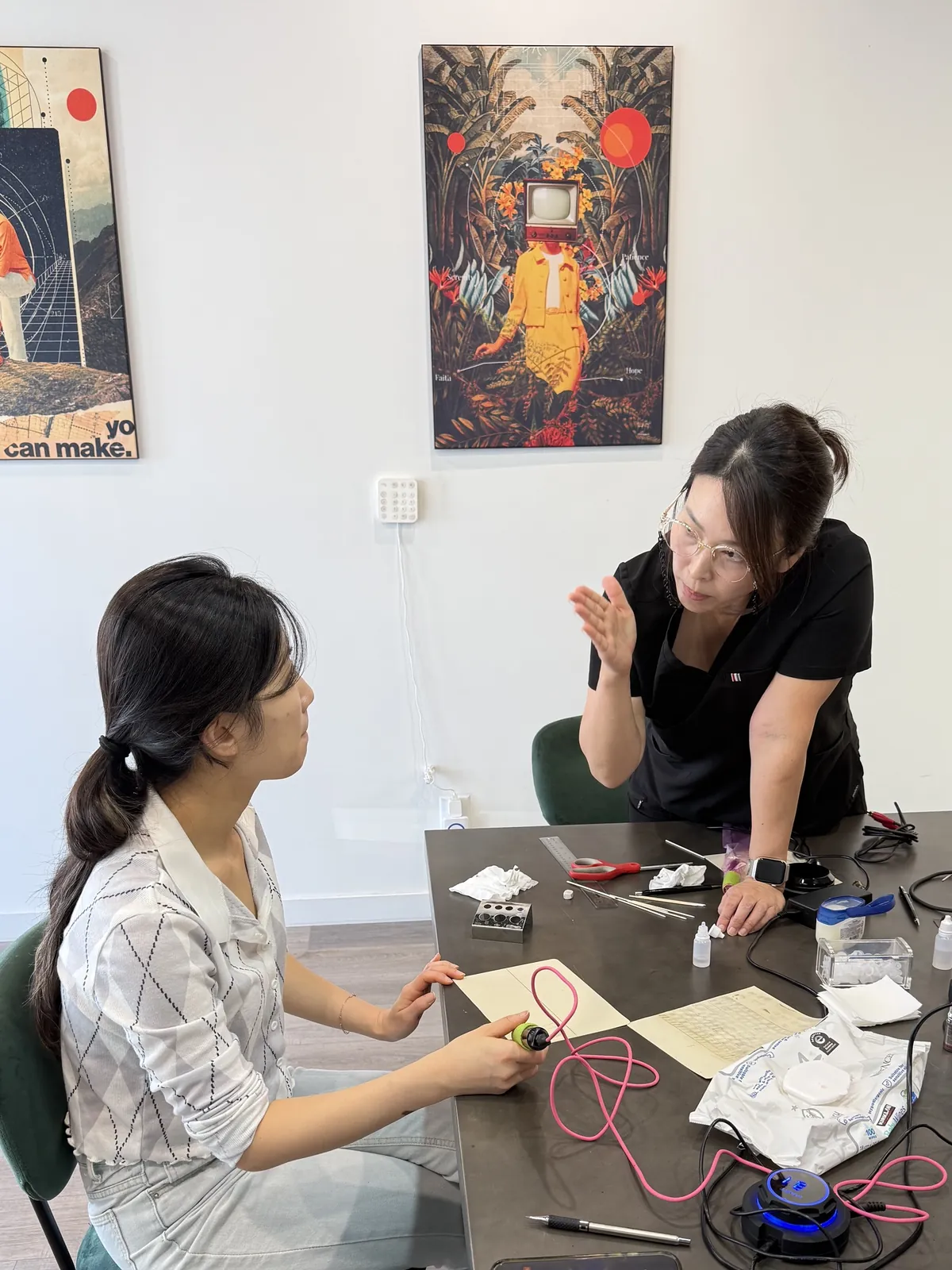 PMU instructor explaining technique as a beginner student practices on latex skin at SUNNYBROW Academy in Los Angeles